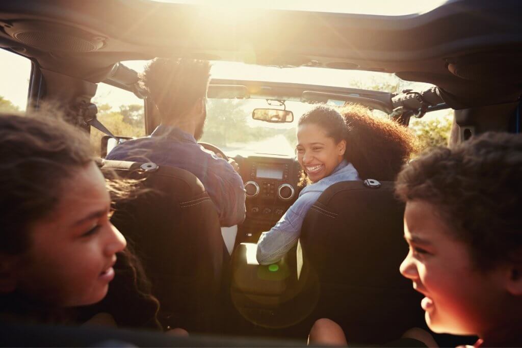 family in a car taking off on a road trip