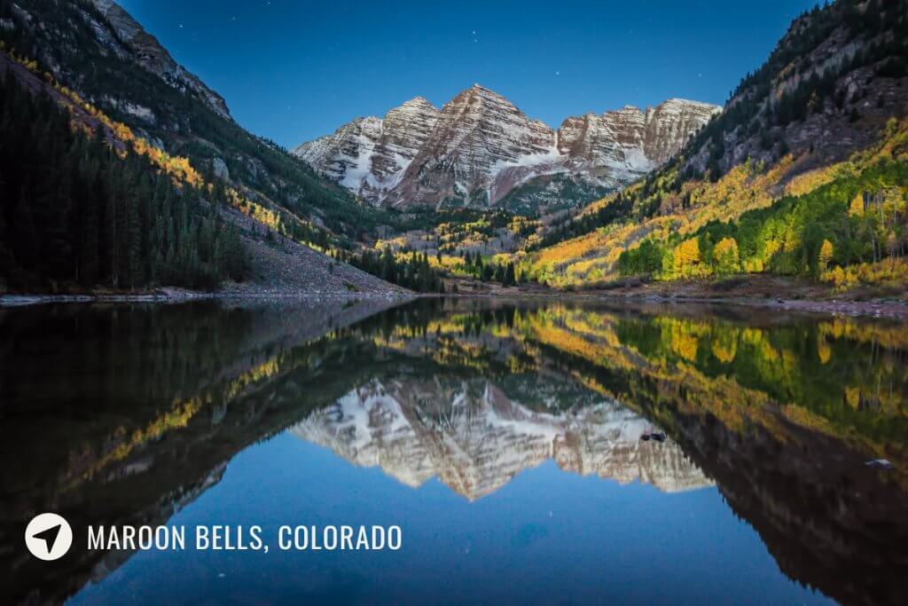 maroon lake and maroon bells near aspen in colorado lit under moonlight with reflection of the mountains on the lake