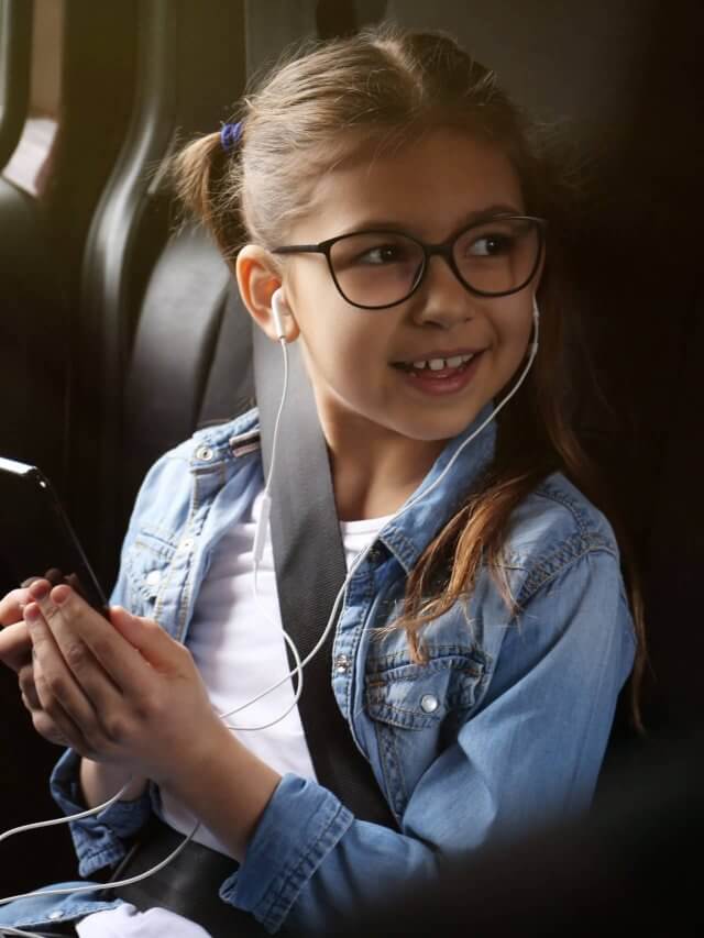Cute little girl listening to audiobook in car