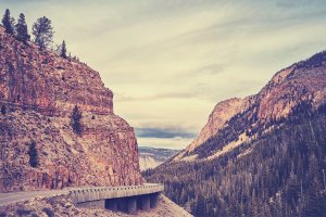 a road hugging the cliffside in yellowstone national park